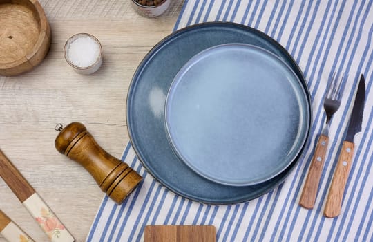Empty round ceramic plate on the table with spices, top view