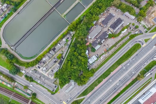 Top view of the urban lake. Lake, road in the city and parking