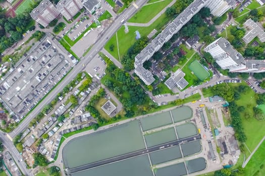 Top view of the urban lake. Lake, road in the city and parking