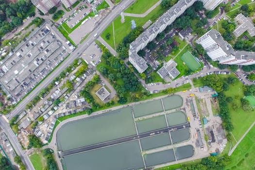 Top view of the urban lake. Lake, road in the city and parking