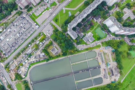Top view of the urban lake. Lake, road in the city and parking