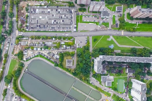 Top view of the urban lake. Lake, road in the city and parking