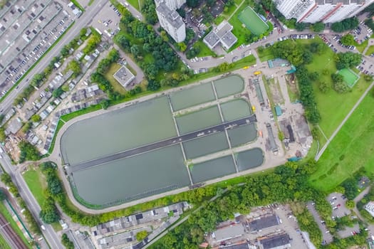 Top view of the urban lake. Lake, road in the city and parking