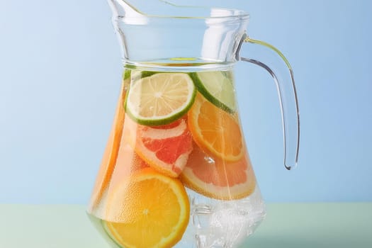 Close-up of a refreshing fruit-infused water pitcher with ice cubes and slices of citrus fruits.