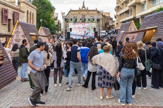 Baku, Azerbaijan - May 4 2024: Crowd gathers for a concert at the first National Carpet Festival of Azerbaijan. The event takes place in the Old Town, or Icherisheher, the historic walled city