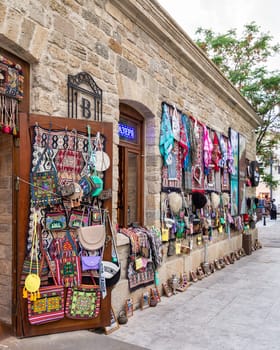 Baku, Azerbaijan - May 4 2024: An open doorway reveals a shop in the historic Icherisheher district of Baku, showcasing colorful woven rugs, bags, and other traditional goods for sale