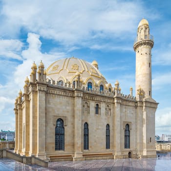 The majestic Taza Pir Mosque in Baku, Azerbaijan showcases intricate architecture with twin minarets against a peaceful morning clear sky