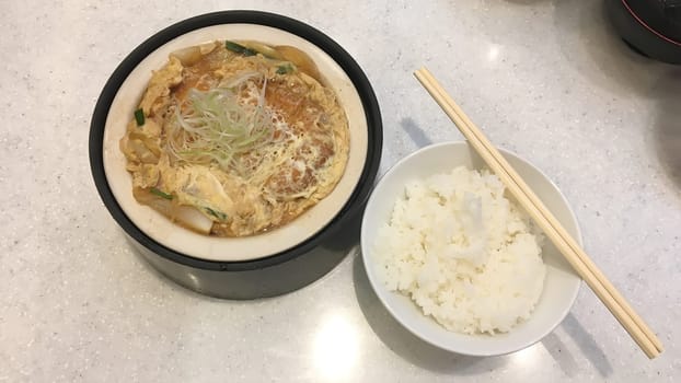 Fried pork tonkatsu with egg, served with white rice.