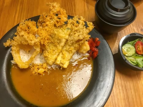 Golden tempura atop Japanese curry rice.