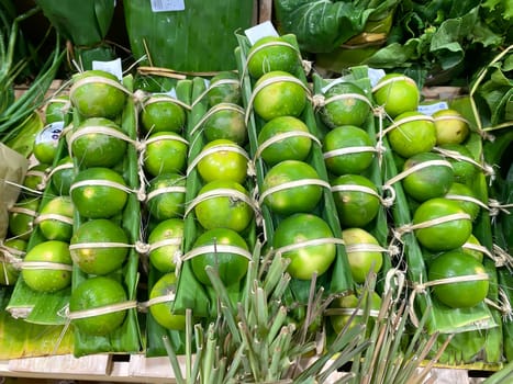 Lots of lemons tied into packages on a market stall.