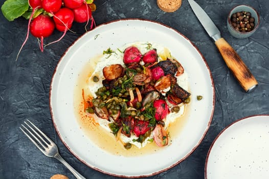 Roasted radish salad or piccata on a concrete kitchen table. Vegetarian piccata, Italian food.