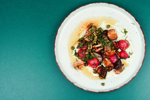 Roasted radish salad or piccata on a concrete kitchen table. Vegetarian piccata, Italian food.