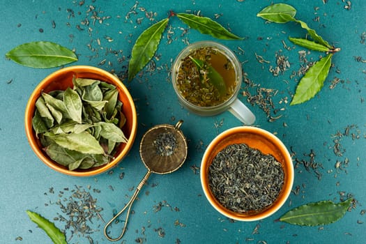 Healthy bay leaf tea on rustic wooden table. Herbal medicine, homeopathic herbs.