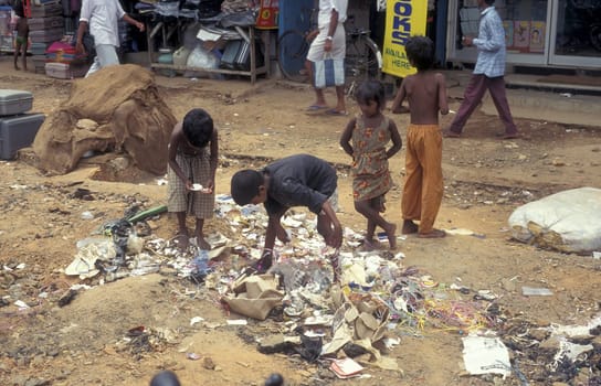 poor people and children with some food on a square in the city of Chennai in Province Tamil Nadu in India.  India, Chennai, April, 1998