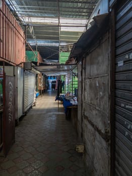 empty narrow passage between trading containers in Dordoi Bazaar in Bishkek, Kyrgyzstan - March 20, 2023