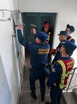 Rescuers from the Ministry of Emergency Situations of Kyrgyzstan break open a metal door to an apartment in an apartment building in Bishkek, Kyrgyzstan April 22, 2023