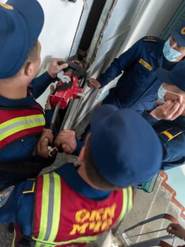 Rescuers from the Ministry of Emergency Situations of Kyrgyzstan break open a metal door to an apartment in an apartment building in Bishkek, Kyrgyzstan April 22, 2023