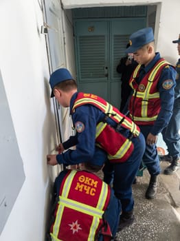 Rescuers from the Ministry of Emergency Situations of Kyrgyzstan break open a metal door to an apartment in an apartment building in Bishkek, Kyrgyzstan April 22, 2023