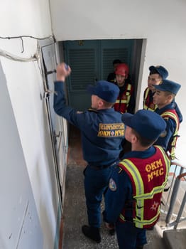 Rescuers from the Ministry of Emergency Situations of Kyrgyzstan break open a metal door to an apartment in an apartment building in Bishkek, Kyrgyzstan April 22, 2023