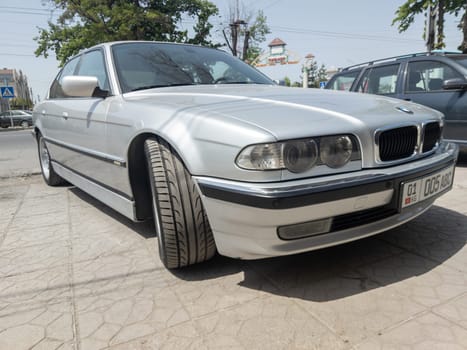 perfectly saved silver BMW 740i E38 on sunny summer streets of Bishkek, Kyrgyzstan - June 9, 2023