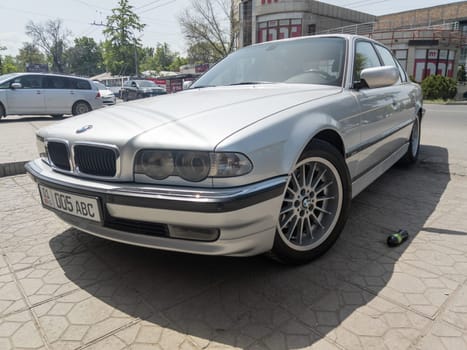 perfectly saved silver BMW 740i E38 on sunny summer streets of Bishkek, Kyrgyzstan - June 9, 2023