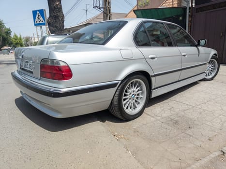 perfectly saved silver BMW 740i E38 on sunny summer streets of Bishkek, Kyrgyzstan - June 9, 2023