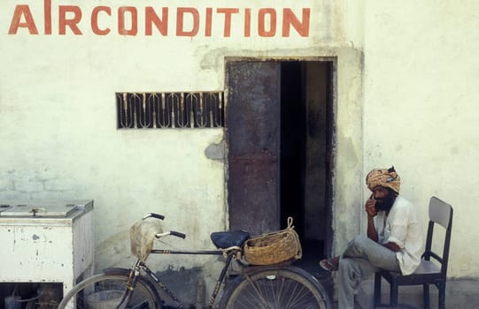 a men by very hot weather at a guesthouse with aircondition in the city of Khajurao in Province Madhya Pradesh in India.  India, Khajurao, April, 1998