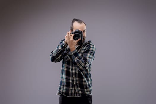 Confident photographer framing shot with professional camera in studio. Passionate hobbyist showcases creativity and skill