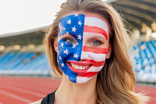 Sports fan with the American flag painted on their face in a sports stadium during a competition.