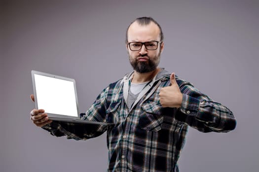 Web developer is holding a laptop with a blank screen and giving a thumbs up of approval for internet security and computer science