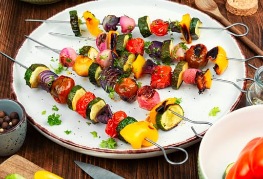 Grilled vegetable kebabs, skewers with vegetables on a wooden rustic table.
