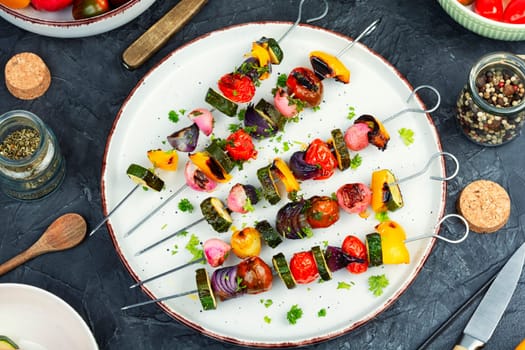 Grilled vegetable kebabs, skewers with vegetables on a wooden rustic table.
