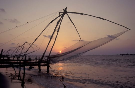 the Chinese Fishing Net by sunset at the Coast in the city of Kochi or Cochin in the Province Kerala in India.  India, Cochin, April, 1998