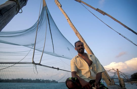 a fishingmen at the Chinese Fishing Net on the Coast in the city of Kochi or Cochin in the Province Kerala in India.  India, Cochin, April, 1998