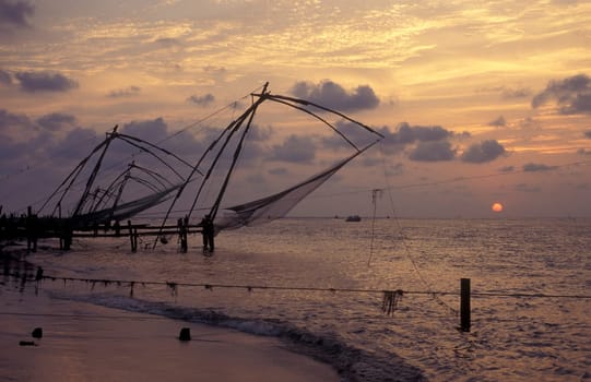 the Chinese Fishing Net by sunset at the Coast in the city of Kochi or Cochin in the Province Kerala in India.  India, Cochin, April, 1998