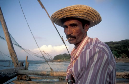 a fishingmen at the Chinese Fishing Net on the Coast in the city of Kochi or Cochin in the Province Kerala in India.  India, Cochin, April, 1998
