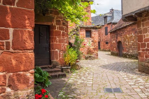 Red houses seen from a street in Collonges-la-Rouge, one of the most beautiful villages in France, Corrèze