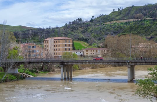 Modern concrete bridge of Puente La Reina, Navarre, Spain. River Arga flowing  turbidly
