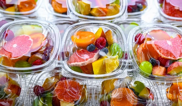 Plastic boxes with pre-packaged fruit salads, put up for sale in a commercial refrigerator