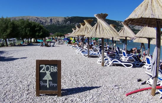 Quite nicely expensive: Sun lounger for 20 euros daily fee on the beach of Baska/island of Krk  Theme picture Croatia / Hrvatska / Croatia 2024