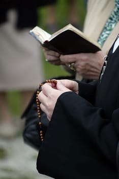 Hands of a woman holding a rosary while praying, Christian daily devotional of a worshiper of God the Savior, Basilica of Assumption of the Virgin Mary in Marija Bistrica, Croatia