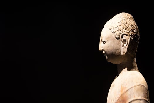 Turin, Italy - 28 December 2023: Oriental Art Museum, Standing Buddha, Northern China, late 6th c.. Copy space, black background