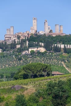 San Gimignano village, Italy - green countryside, blue sky, hill panorama with town and towers