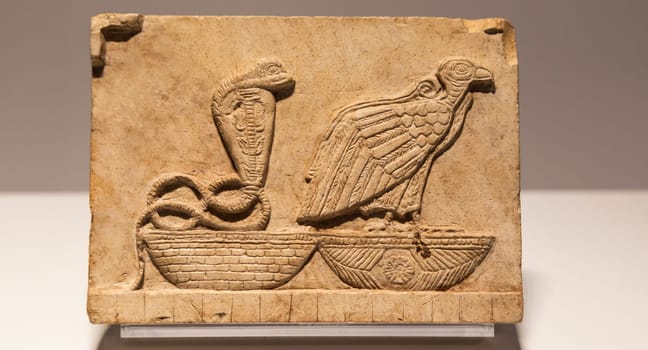 Turin, Italy - 28 December 2023: Egyptian Museum. Plaque with vulture and cobra, limestone, 400 BC