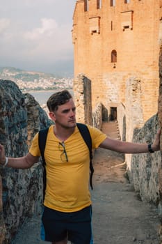 Man at fortress ruins of the historical Red Tower - Kizil Kule, in Alanya Castle, the famous touristic place.