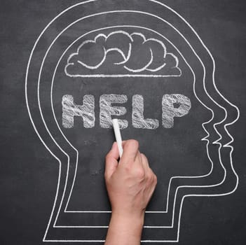 The silhouette of a human head is drawn on a black chalk board, the inscription help. Mental health concept, stress