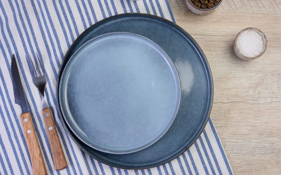 Empty round ceramic plate on the table with spices, top view