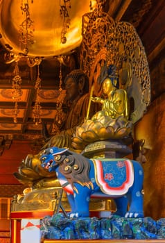 tokyo, ueno - jan 09 2024: Buddhist statues of the Japanese deity Monju on a blue tiger, symbol of intelligence and wisdom next to the bodhisattva Shaka, symbol of compassion in the Gokokuin temple.