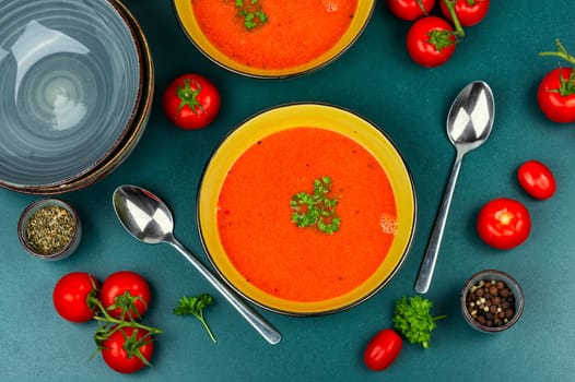 Dietary cream soup made from fresh tomatoes on rustic wooden table. Vegetable tomato soup.