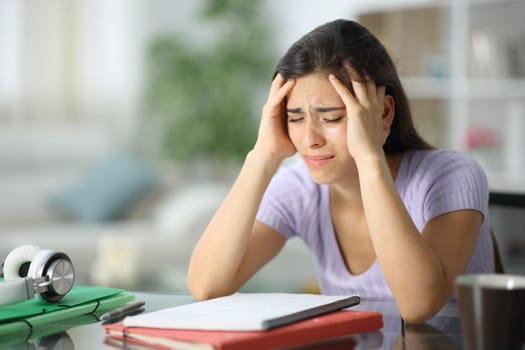 Worried student complaining alone sitting at home